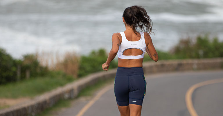 Mulher correndo na estrada vestindo a Linha GRIT da Authen | Como sair da obesidade com a corrida?