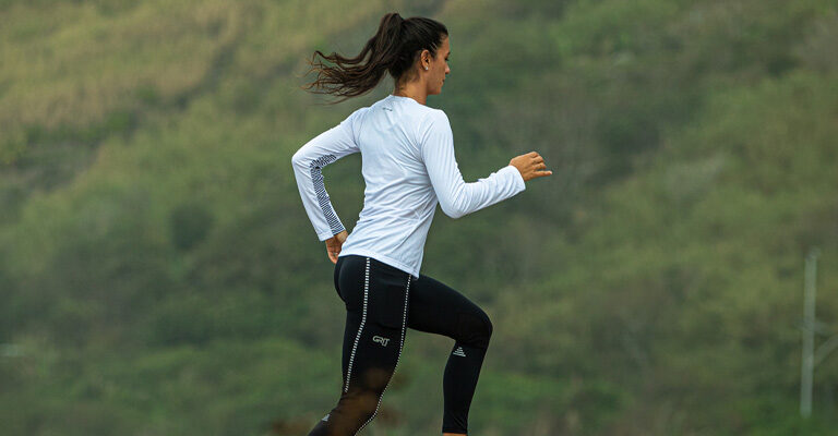 Mulher correndo em trilha, usando GRIT Trail Authen | Como migrar da rua para a corrida de montanha?